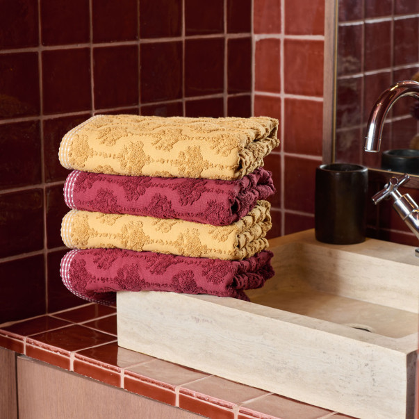 Drap de douche Néroli en éponge jacquard ciselée, disponible en curry et prune.