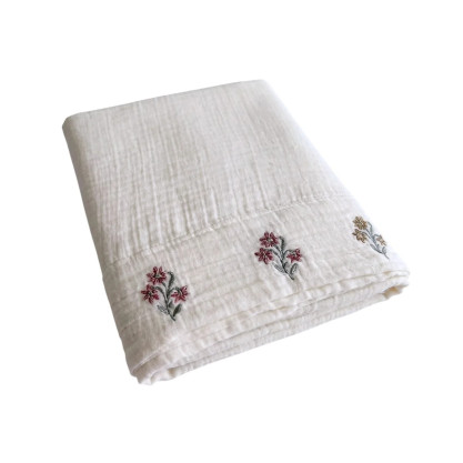 Détail du parement brodé du drap plat Néroli et de ses motifs floraux délicats.