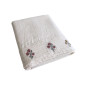Détail du parement brodé du drap plat Néroli et de ses motifs floraux délicats.
