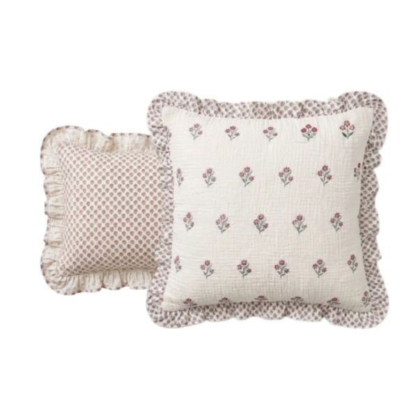 Taies d’oreiller Néroli en triple gaze de coton, aux motifs floraux et aux finitions volantées.