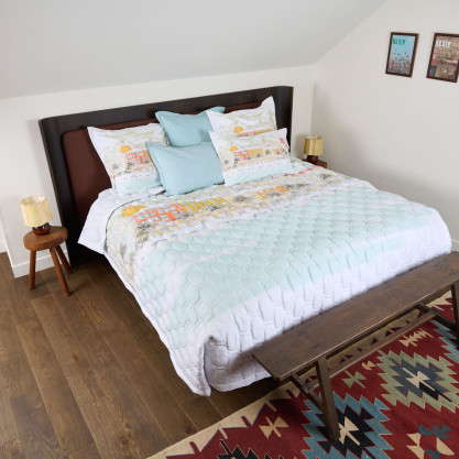 Couvre-lit matelassé Nice présenté sur un lit, avec son motif coloré inspiré de l’atmosphère ensoleillée de la Riviera.
