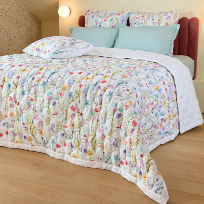 Couvre-lit matelassé Sophie en percale de coton, avec imprimé aquarellé de fleurs des champs aux nuances colorées.
